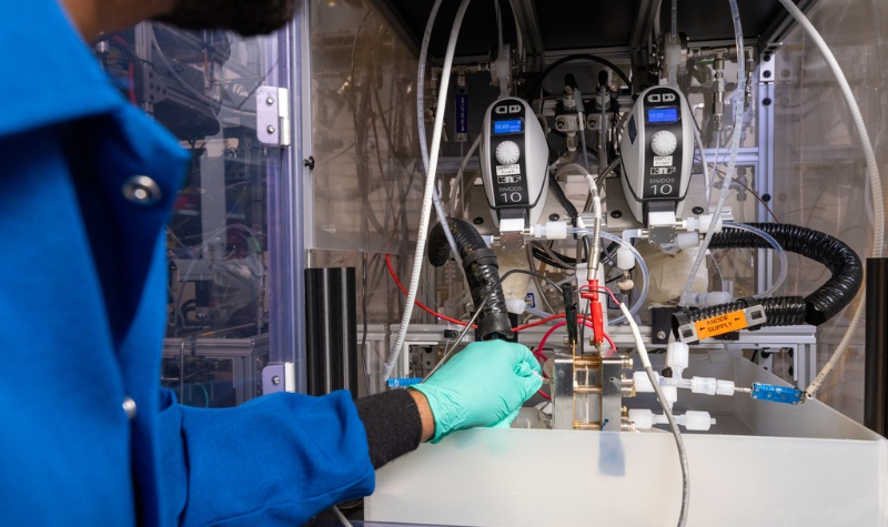 Person testing electrolyzer performance using lab equipment