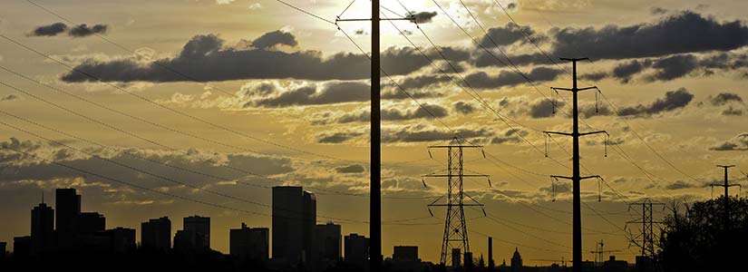 Transmission lines near a city skyline.