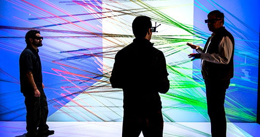 Photo of three researchers looking at a 3-D visualization.