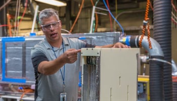 Person working on metal box in manufacturing lab