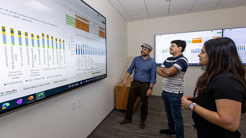 mfi-researchers Three people stand and look at data on large display