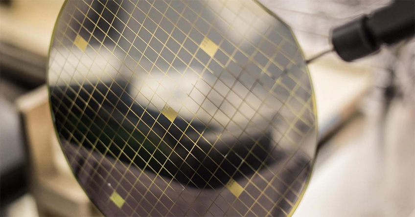 sic-wafer A translucent silicon wafer is at the foreground with a blurred background.
