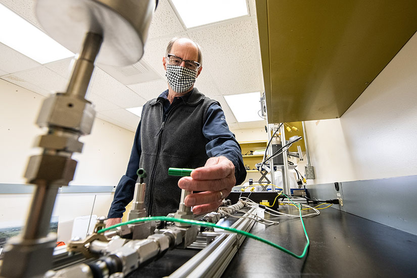 A scientist examines a piece of laboratory equipment.