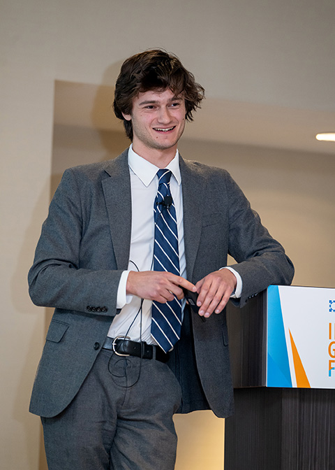 20250421-record-attendance-at-30th-annual-nrel-industry-growth-forum-as-innovation-soars-michael-pitch A man smiles while leaning on a podium.