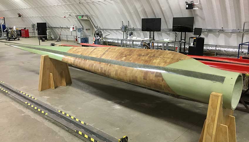 A wind blade on a stand in a warehouse.