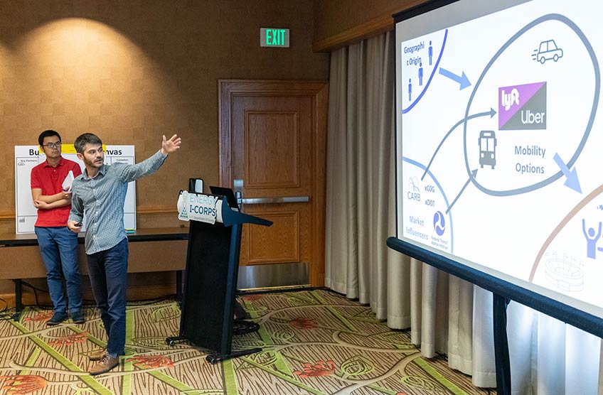 Two NREL researchers point to a screen that says