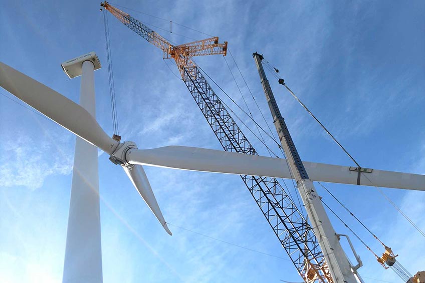 Photograph of a crane lowering a wind turbine rotor.