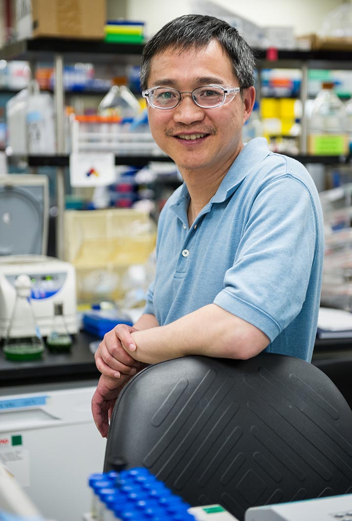 A photo of a scientist standing in the lab