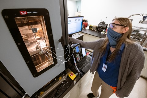 A woman operating lab equipment.