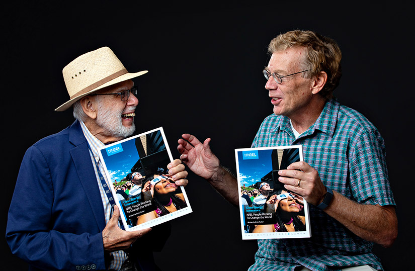 Two men talk while each holds a book.