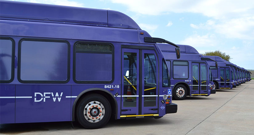 A row of blue electric buses at Dallas Fort Worth International Airport.