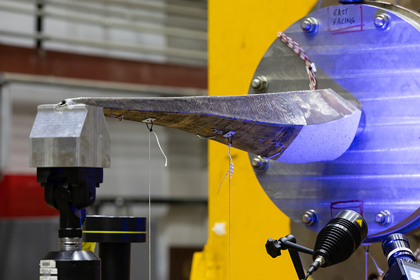 A 3D printed spar component prepares to be tested in a lab