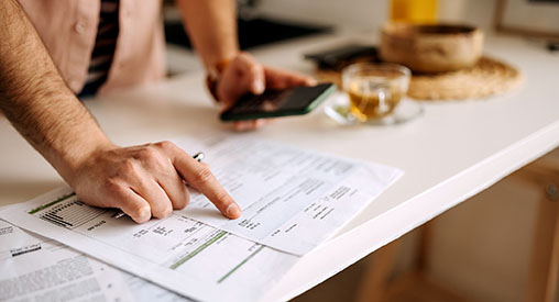 A man using a calculator on the phone to calculate expenses