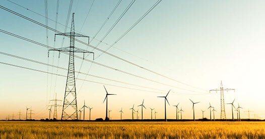 Wind turbines in a field at sunset