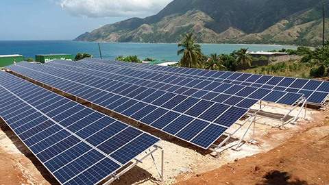 Solar panel array in front of ocean.