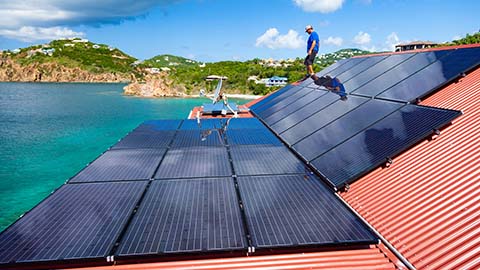 Person walks on rooftop solar panels.