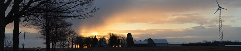 Wind turbine on a farm at sunset