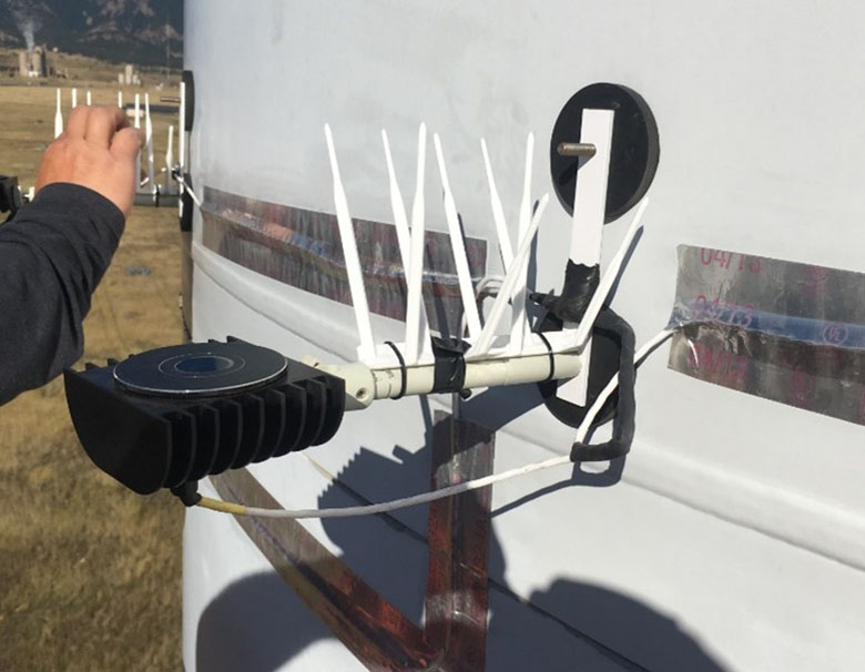 A device with antennae attached to a wind turbine tower