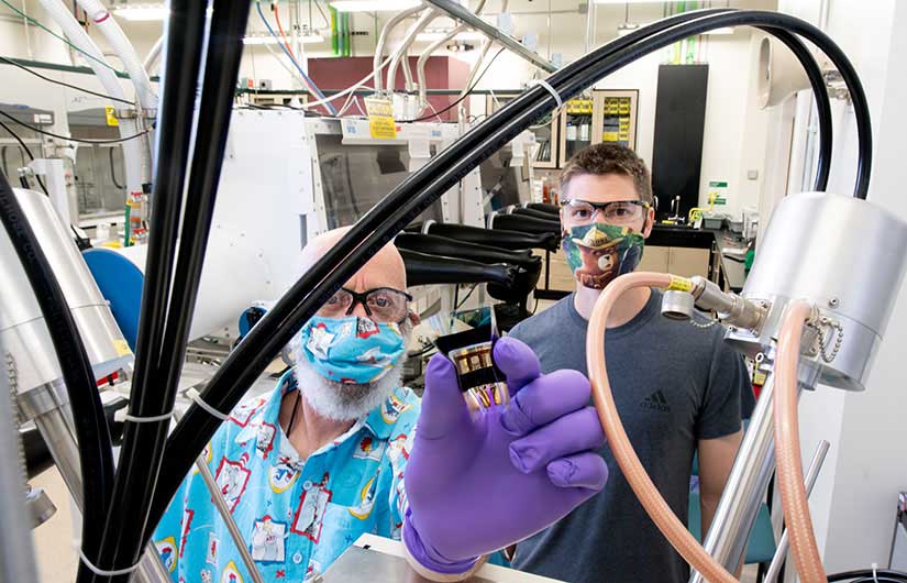 Two researchers in the lab holding a flexible solar cell.