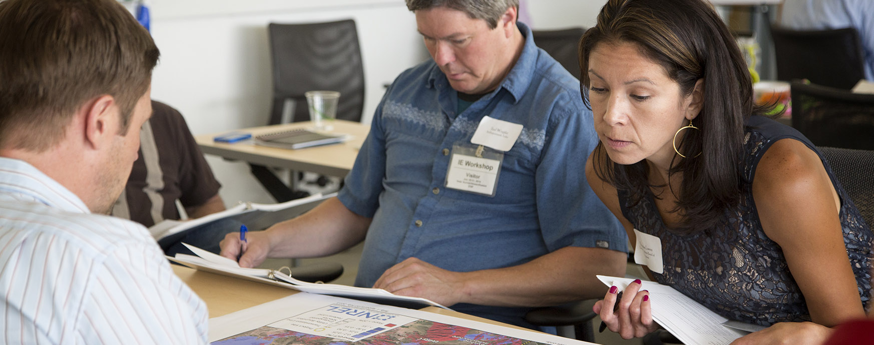 Photo of a group of people discussing a map.