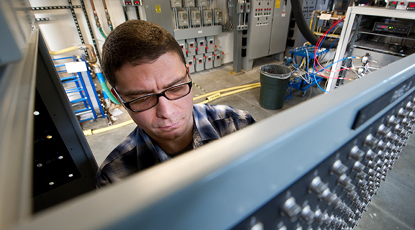 Photo of a man operating a data acquisition panel in a laboratory