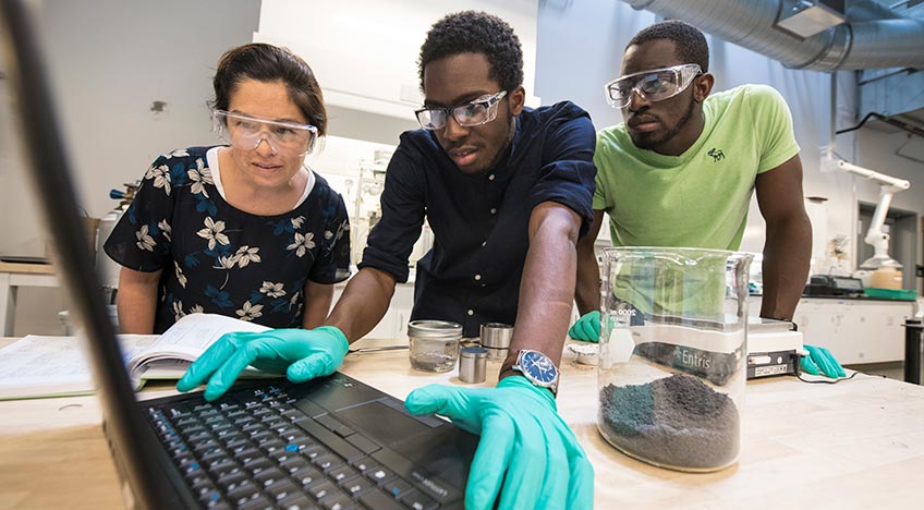 An intern works with mentors in NREL’s Thermal Storage Process and Components Laboratory