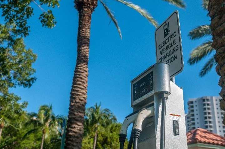 1-201806-tech-integration-powertrains Level 2 electric vehicle supply equipment in front of a palm tree in California