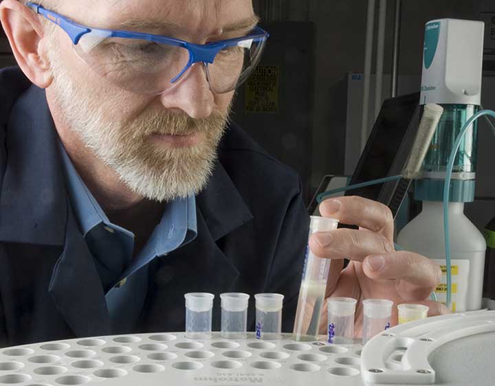 2018-09-photo-09 A man wearing goggles examines a biodiesel sample in NREL's Fuel Chemistry Laboratory.